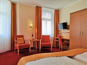 宾茨美瑞格斯酒店的酒店客房配有一张床、椅子和一张书桌
