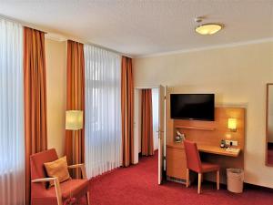 宾茨美瑞格斯酒店的酒店客房配有带电视和椅子的书桌