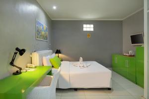 NegaraNegara Hotel - CHSE Certified的一间卧室配有一张床和一张带台灯的书桌