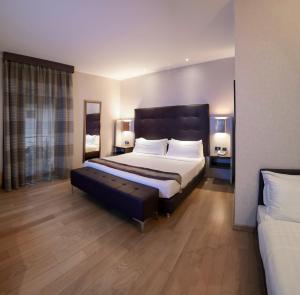 菲乌米奇诺Rome Airport Hotel Fiumicino的一间卧室配有一张大床和一张沙发