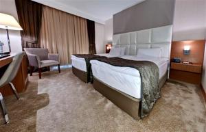 阿达纳Riva Reşatbey Luxury Hotel的酒店客房设有一张大床和一张书桌。