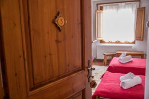 内莱多科利Ξενώνας Πατρικό的一间卧室配有两张带红色床单和白色毛巾的床