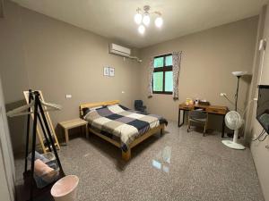 鹿港镇哈楼民宿的一间卧室配有一张床、一张桌子和一台摄像机