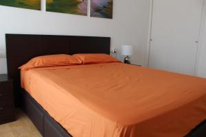 霍斯皮塔勒·德尔英福Apartamento en primera línea de mar的卧室里的橙色床罩