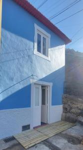 蓬他达维托亚Madalena Beach Tiny House的蓝色和白色的建筑,设有门和窗户