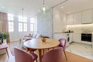 维亚纳堡Santa Luzia Views - Modern City Centre Apartment with Iconic Views的厨房以及带桌椅的起居室。