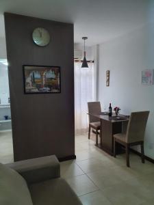 萨尔瓦多APARTAMENTO ITAIGARA的客厅配有桌子和墙上的时钟