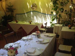 罗马兰斯洛特酒店的用餐室设有2张带盘子和酒杯的桌子