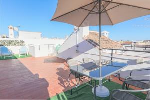 福恩吉罗拉Apartamento del Sol的一个带桌子和遮阳伞的庭院