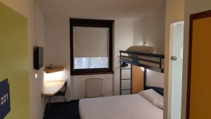 蒙托邦Kyriad Direct Montauban Centre的一间卧室配有双层床、书桌和窗户。