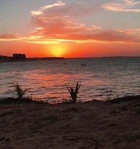 拉戈伊尼亚EDEN Pousada的海滩上的日落,日落在水面上