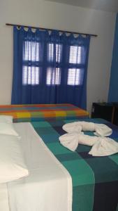 拉戈伊尼亚EDEN Pousada的一间卧室配有两张带毛巾的床