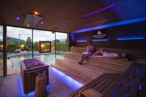 布鲁尼科Majestic Hotel & Spa Resort的两人坐在带游泳池的桑拿浴室