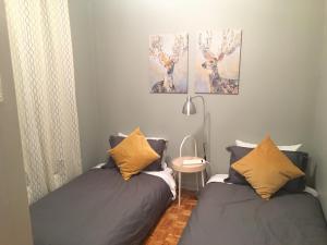 隆格伊Le Milka II的一间卧室配有两张床、一张桌子和两幅画作