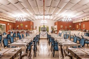 凯里尼亚Grand Pasha Hotel & Spa Kyrenia的宴会厅配有桌椅和吊灯