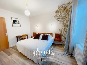 奥布拉克La Domerie - Maison d'hôtes的一间卧室配有带白色床单和棕色枕头的床。