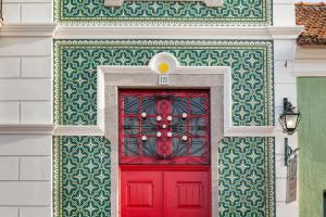 欧瓦Vintage Balcony Guesthouse的建筑上一扇红门,墙上有绿色的白色墙