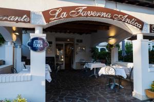 佩斯卡拉La Taverna Antica Rooms的一间带桌椅和标志的餐厅