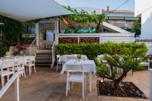 佩斯卡拉La Taverna Antica Rooms的庭院里的餐厅配有白色的桌椅