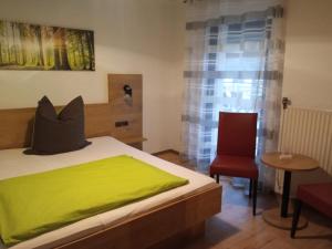 梅斯佩尔布伦Gasthof Zum Löwen的一间卧室配有一张带绿毯的床和一把椅子