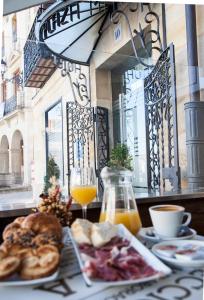 索里亚索利亚市长广场酒店的一张桌子,上面放着一盘食物和一杯橙汁