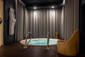 里斯本里斯本科尔坡圣托历史酒店的浴室设有按摩浴缸和窗帘