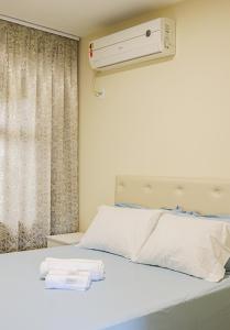 波梅罗迪Apê Jabuticabeira的卧室配有白色床和空调