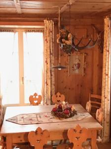 莱维科特尔梅Villa Gioia的一间带木桌和窗户的用餐室