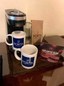 危地马拉安地瓜门安提瓜酒店的一张桌子,上面放着两个咖啡杯和咖啡壶