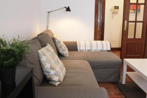毕尔巴鄂Bilbao Apartment Lasai con parking directo的客厅配有带枕头的沙发。