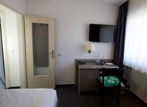 科隆梅里安酒店的酒店客房设有一张桌子和一台墙上的电视。