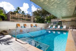 檀香山Ohia Waikiki Studio Suites的一个带躺椅的游泳池和一个游泳池