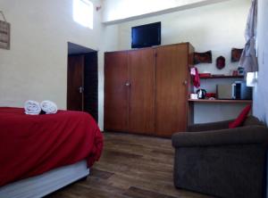 SabieSabi falls accommodation的一间卧室配有一张床、一把椅子和一个橱柜