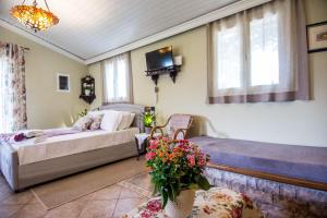 阿尔戈斯托利翁Villa Aelia - A Peaceful And Private Place的一间卧室配有两张床和一张鲜花桌