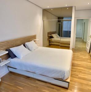 毕尔巴鄂Habitación privada en Bilbao Centro的卧室配有一张白色大床和镜子