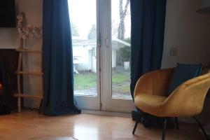 恩斯赫德Chalet op mooie rustige plek的客厅配有椅子和滑动玻璃门