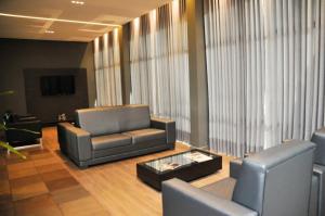 埃雷欣Hotel Vivendas Centro的大堂设有两把椅子、一张沙发和一张桌子