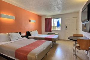 奥斯汀Motel 6-Austin, TX的酒店客房设有两张床和一张桌子。