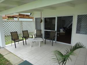 拉罗汤加贝塔拉海滨度假屋 的天井配有两把椅子和一张桌子
