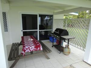 拉罗汤加贝塔拉海滨度假屋 的带烧烤架和野餐桌的屏蔽门廊