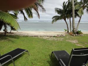拉罗汤加贝塔拉海滨度假屋 的享有带椅子和树木的海滩和大海的景致。