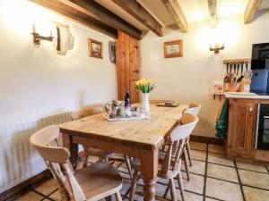 马特洛克Oak Tree Cottage的一间带木桌和椅子的用餐室