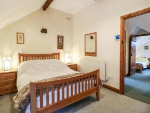 马特洛克Oak Tree Cottage的一间卧室配有木床和镜子