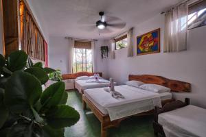 奎波斯城Villas Jacquelina的客房设有四张床、一张沙发和风扇。