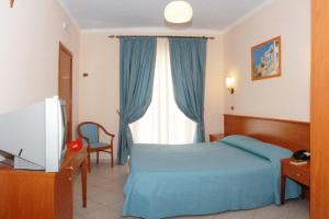 罗迪-加尔加尼科特拉蒙托公寓式酒店的一间卧室设有蓝色的床和窗户。