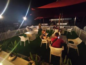 康提杜芭娜山顶住宿酒店的一群人晚上坐在庭院的桌子上