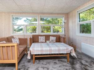 博利尔马克6 person holiday home in R m的客厅配有桌子、沙发和窗户。