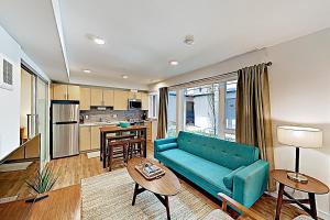 西雅图Atrium Unit 105的一间带蓝色沙发的客厅和一间厨房