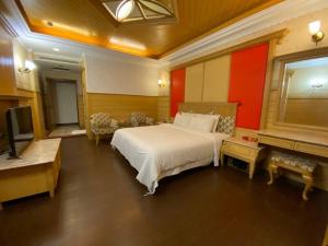 高雄艾旅汽车旅馆(2馆)的一间卧室配有一张大床和电视