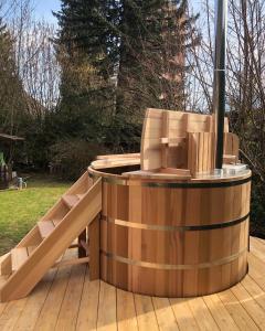 MarignierAU COEUR DES ALPES的木制热水浴缸,位于木甲板上